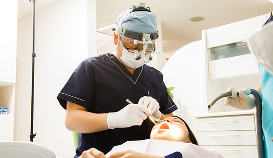 歯の写真を使って説明している医師